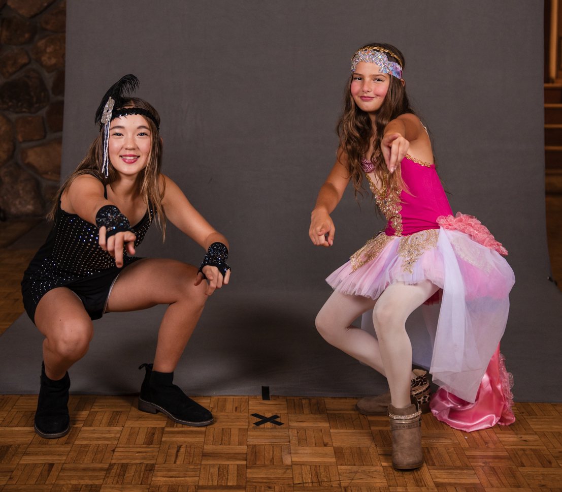 Two dancers, one crouching, on the runway backdrop