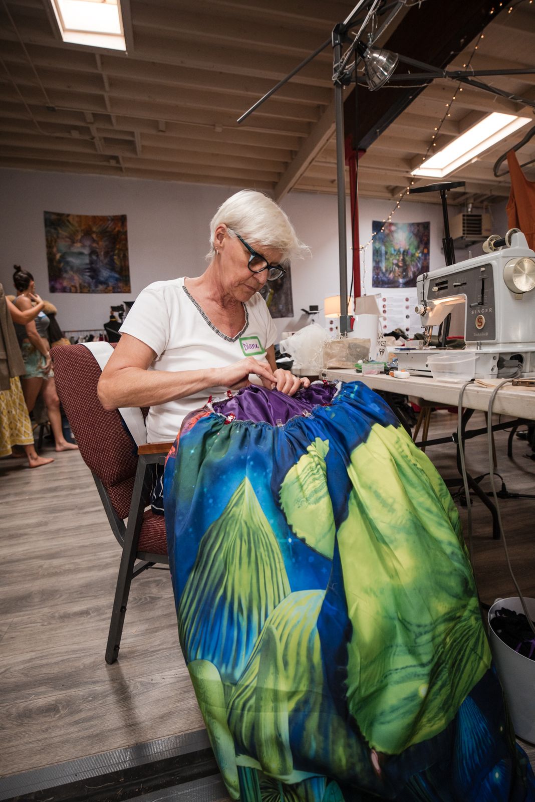 Designer holding up a green and blue silk fabric