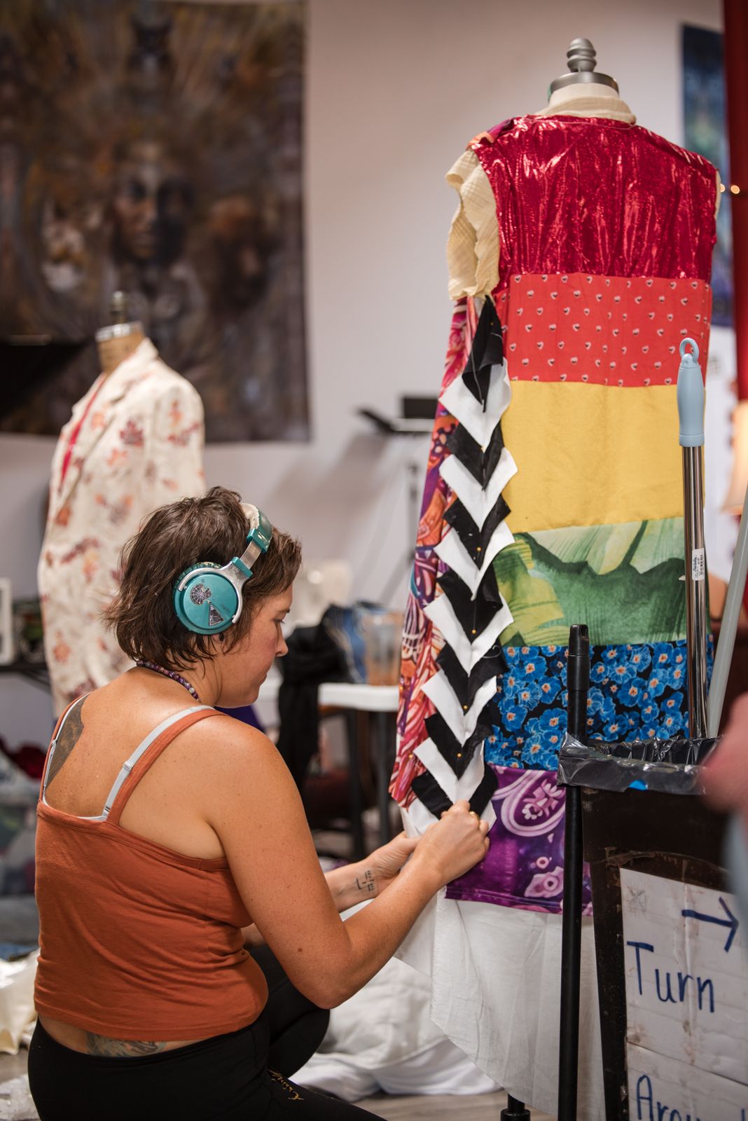 Designer with headphones working on a rainbow striped garment