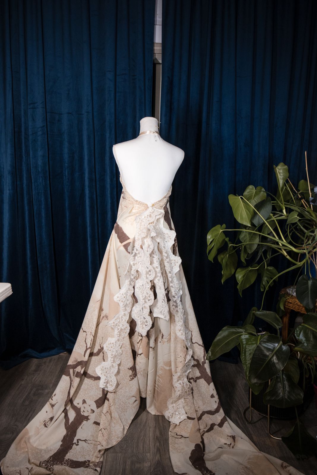 Finished cream gown with a long train on a dress form
