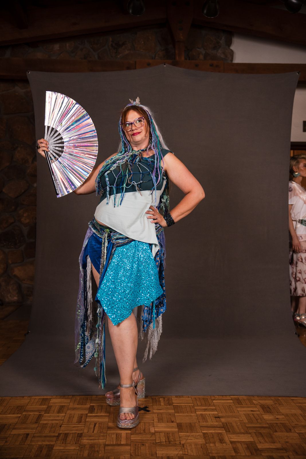 Model with a fan in a teal fringed look