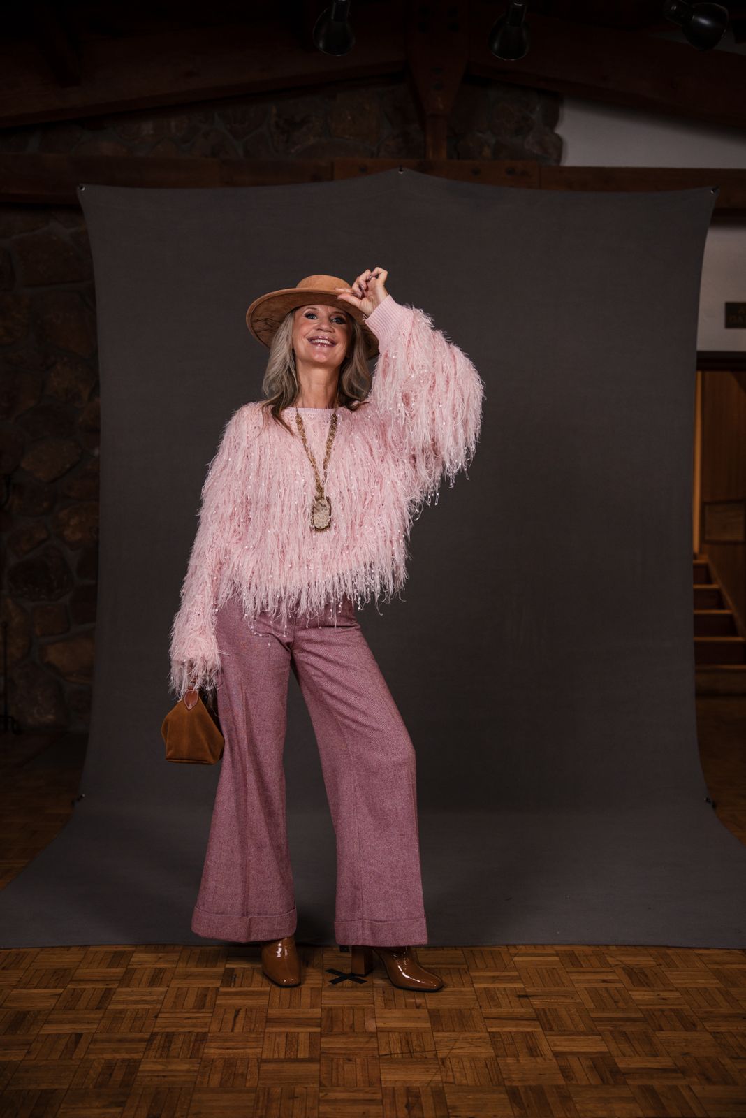 Model in a pink fluffy jacket, hat and flared pants