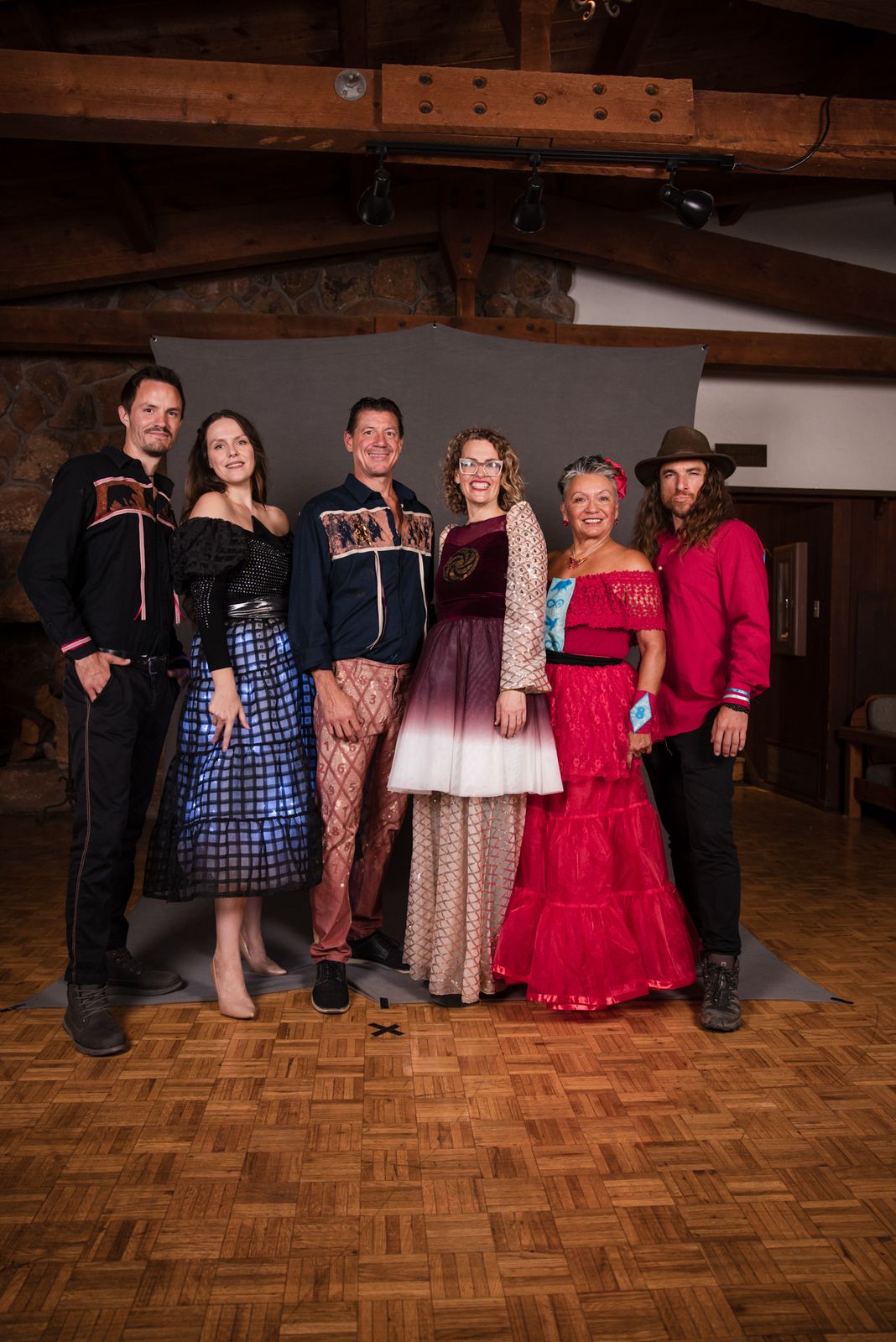 A designer with four models in red, blue and ivory looks